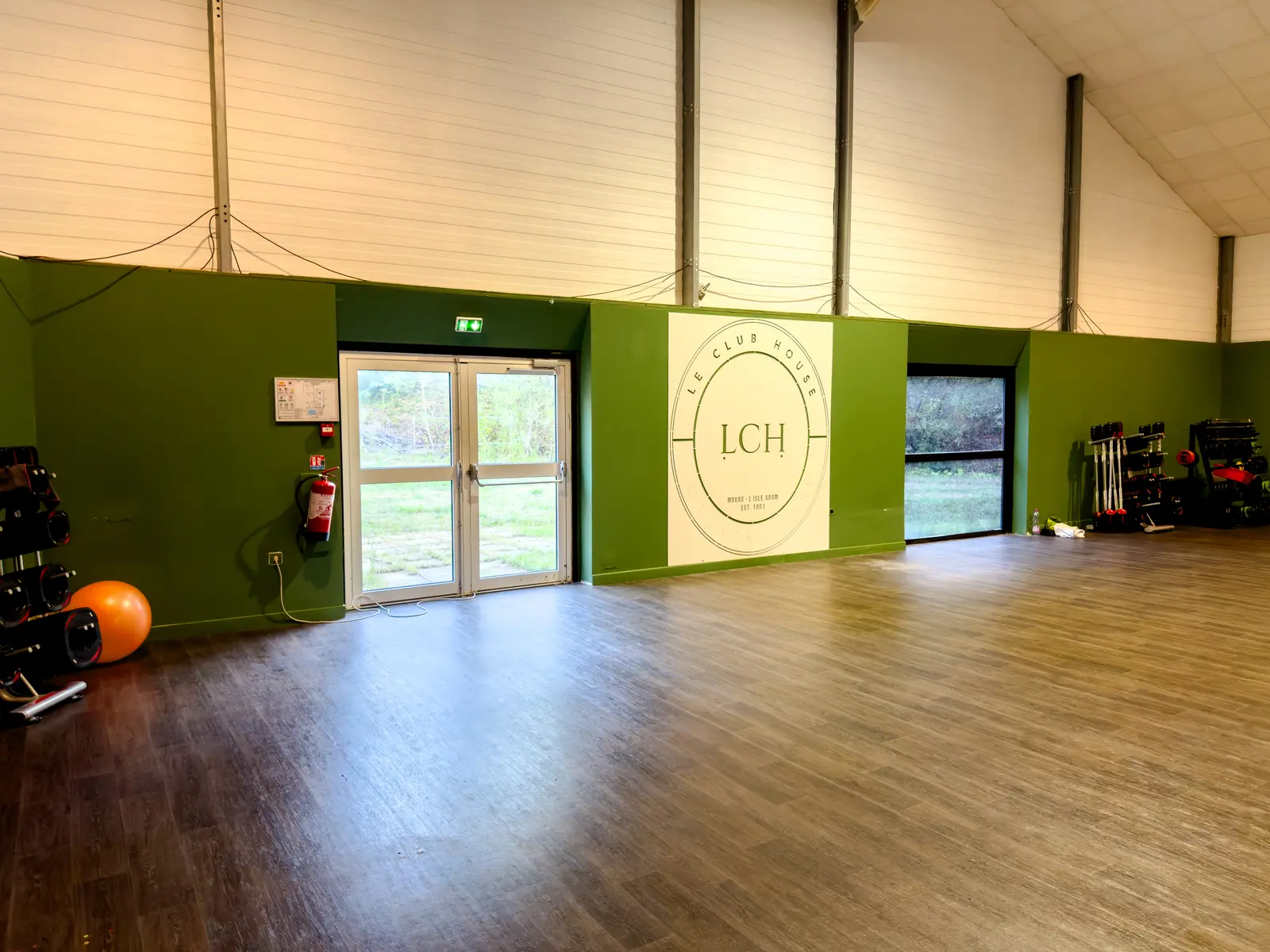 Grande salle de cours collectifs du Club House, vide et lumineuse