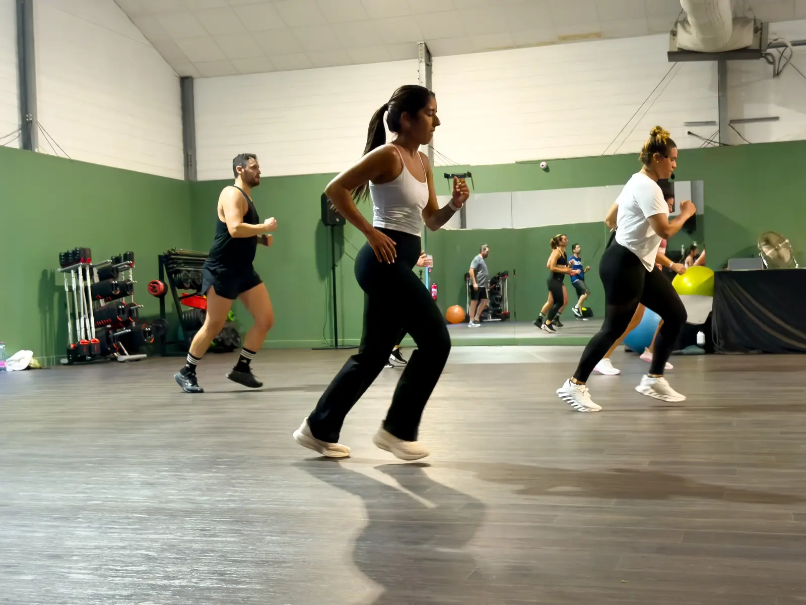 Cours de fitness avec haltères dans la grande salle du Club House